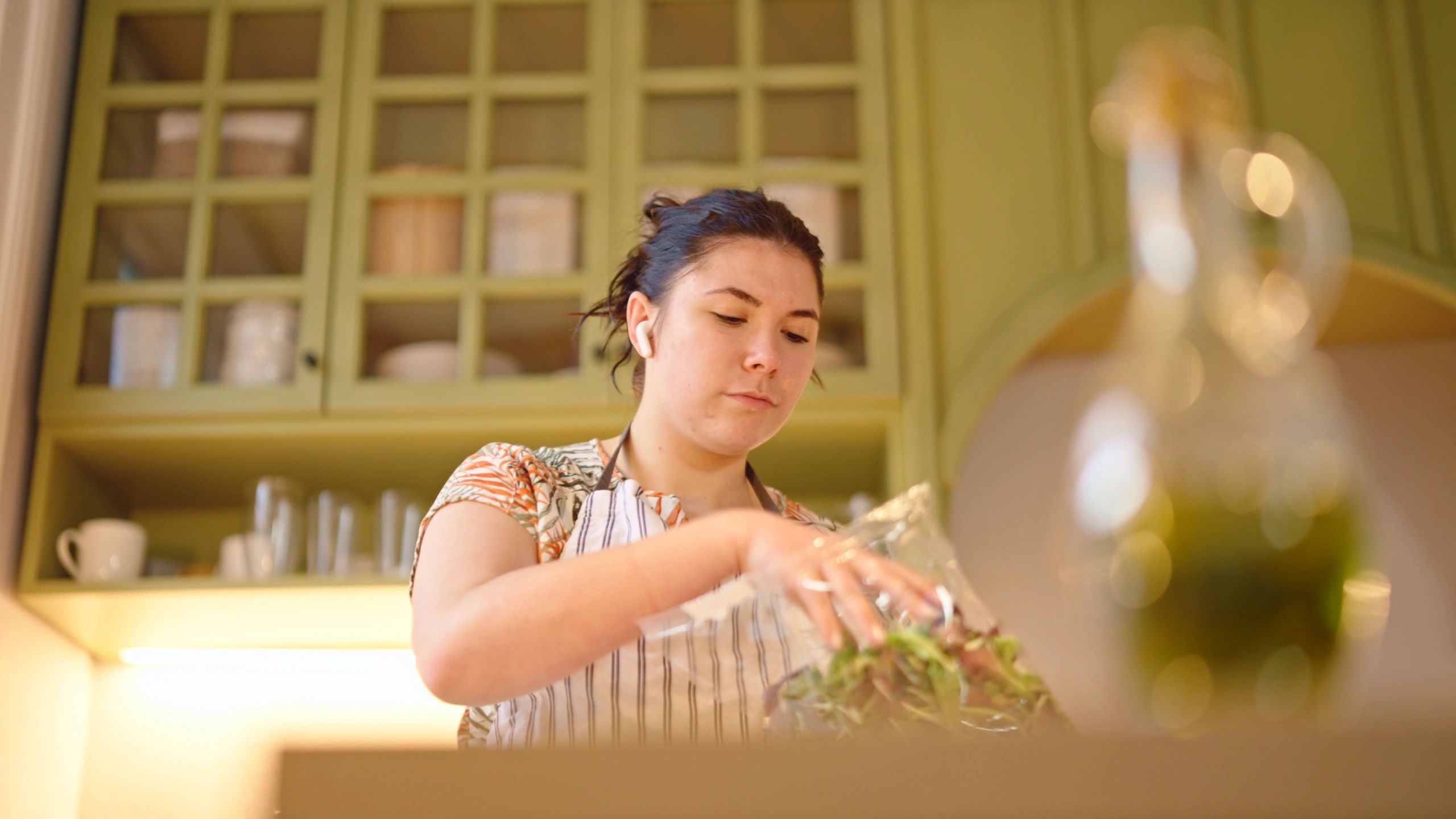 Woman adding fresh herbs while cooking in a home kitchen